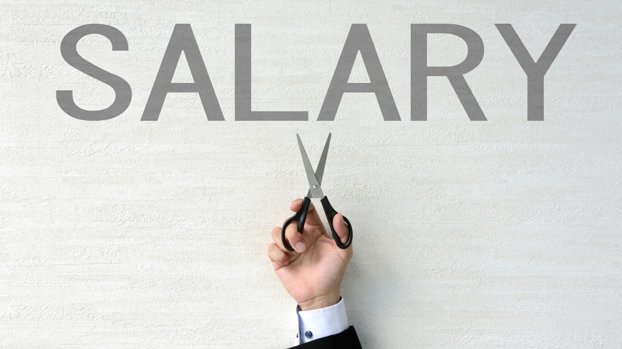 person holding scissors with text saying salary